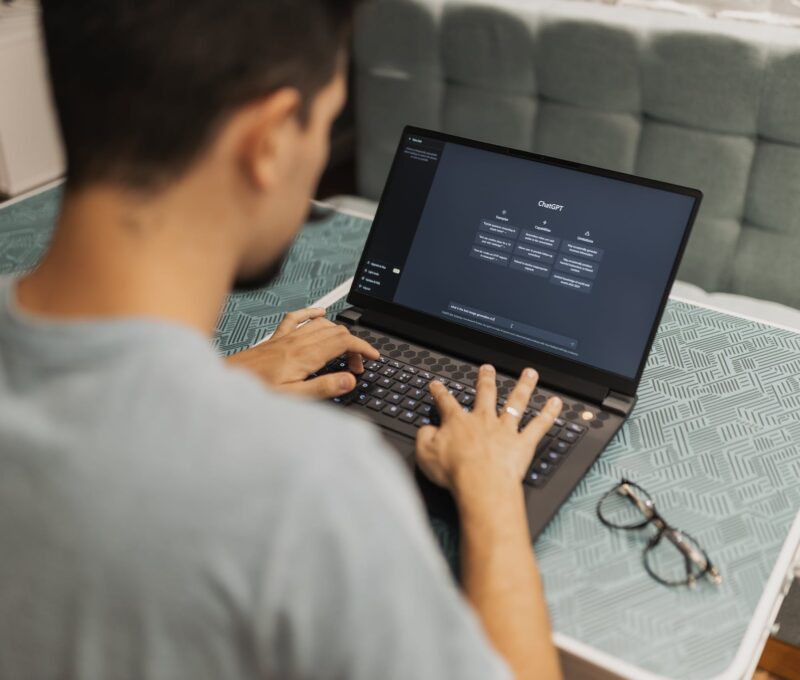 A man is typing on a laptop computer