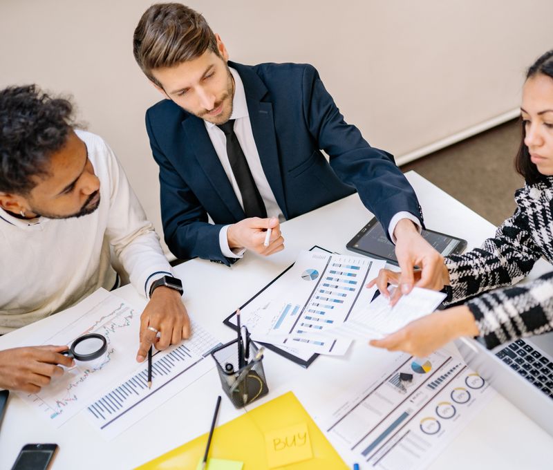 Business professionals engaging in a collaborative meeting with charts and documents.