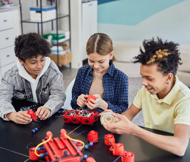 Children collaborating on a robotics project, showcasing teamwork and STEM learning indoors.