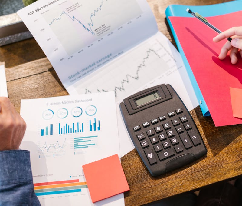 Financial analysis and planning tools with graphs and calculator on a table.