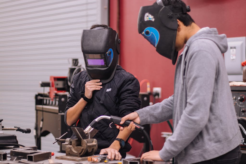 Persons Wearing Protective Gears Using Tools in a Workshop